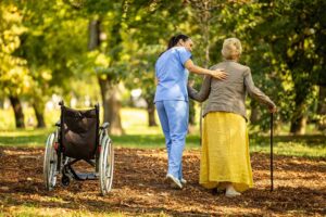 A caregiver assists older adults during an emergency drill in a brightly lit common room.